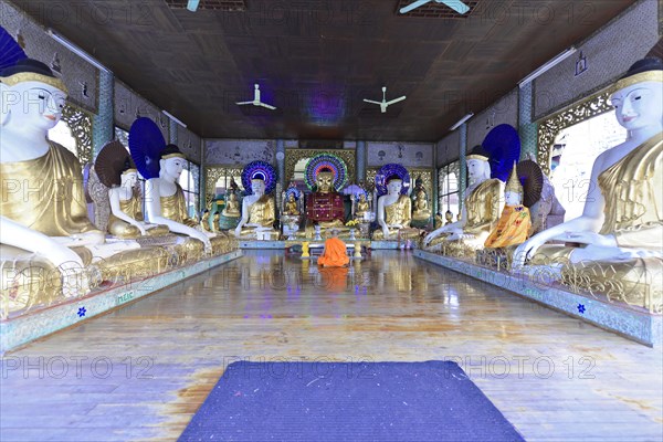 Shwedagon Pagoda, Yangon, Myanmar, Asia, A monk meditates between golden Buddha statues in a temple, Asia