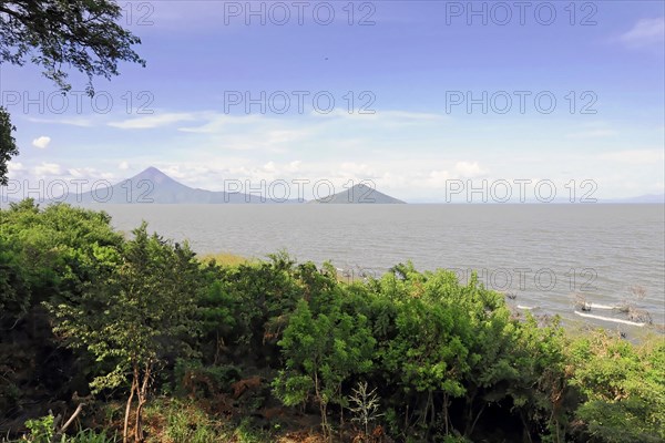 Lake Nicaragua, Ometepe Island in the background, Nicaragua, A tranquil seascape with trees in the foreground and mountains in the background, Central America, Central America