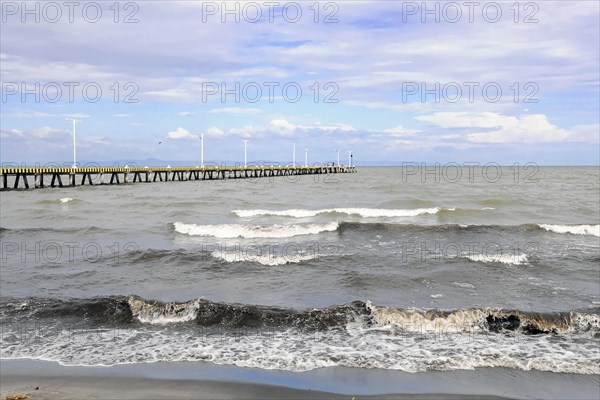 Granada, Nicaragua, Calm waves of Lake Nicaragua meet a long pier under a cloudy sky, Central America, Central America