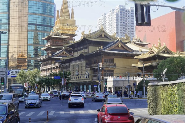 Traffic in Shanghai, Shanghai Shi, People's Republic of China, Traditional temple in front of modern buildings on an urban street with traffic, Shanghai, China, Asia