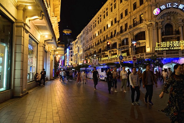 Evening stroll through Shanghai to the sights, Shanghai, on a busy street with shops and passers-by, Shanghai, People's Republic of China