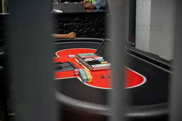 A red poker table with chips and cards, focussed and detailed, Cologne police led a raid against illegal gambling on Friday evening. Around 200 investigators from the police, customs, tax investigation, the public order office, the tax and revenue office, the foreigners authority and the public catering office were out and about on the streets of Cologne on Friday evening. They search 25 properties where there are indications that illegal gambling is taking place. And they make a find