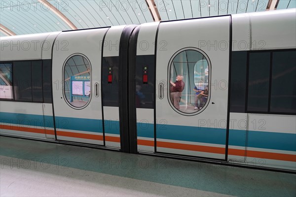 Shanghai Transrapid Maglev Shanghai Maglev Train Station Station, Shanghai, China, Asia, A train at a station with a person visible through the window, urban environment, Asia