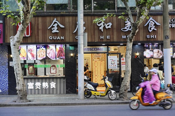 Shanghai, China, Asia, A busy street scene with a restaurant, a scooter and people passing by, People's Republic of China, Asia