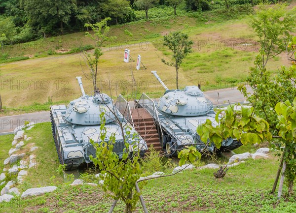 Military tanks with camouflage paint on display in public park near Nonsan, South Korea on overcast day