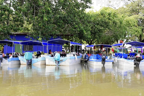 Granada, Nicaragua, Boats on Lake Nicaragua with market stalls and customers under colourful umbrellas, surrounded by nature, Central America, Central America