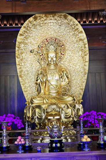 Jade Buddha Temple, Shanghai, Golden Buddha statue on an altar surrounded by pretty flowers, Shanghai, China, Asia