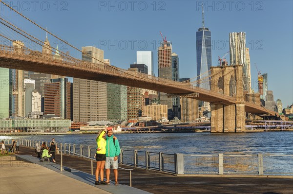 Couple in front of the Manhattan skyline with Brooklyn Bridge and One World Trade Centre, New York City, USA, New York City, New York, USA, North America