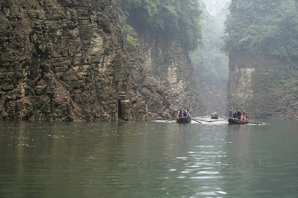 Special boats for the side arms of the Yangtze, for the tourists of the river cruise ships, Yichang, China, Asia, Several boats glide on a foggy river at the foot of steep cliffs, Hubei province, Asia