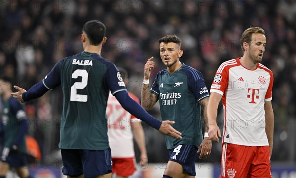 William Saliba Arsenal FC (02) in discussion with Ben White Arsenal FC (04) Harry Kane FC Bayern Munich FCB (09) Allianz Arena, Munich, Bavaria, Germany, Europe