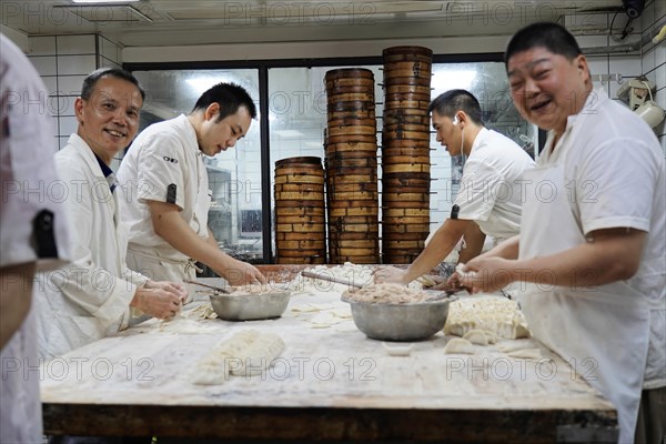 Stroll in Chongqing, Chongqing Province, China, Asia, Kitchen staff prepare dough dishes together in an Asian restaurant, Chongqing, Asia