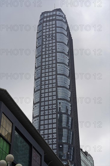 Chongqing, Chongqing Province, China, Asia, A large skyscraper with a glass facade towers into the cloudy sky, Asia