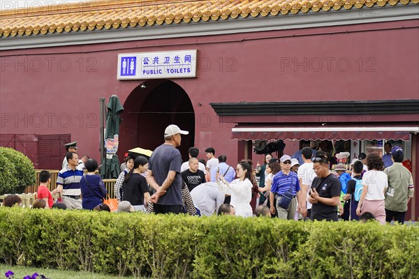 China, Beijing, Forbidden City, UNESCO World Heritage Site, group of visitors near a sign for public toilets at the Forbidden City, Asia