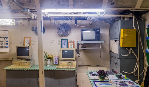 Interior of wardroom with desk chair computer and magazines inside battleship on display at Unification Park in Gangneung, South Korea, Asia