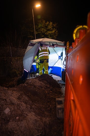 Worker in reflective clothing working at night in an excavation pit under artificial lighting, Galsfaserbau, Calw, Black Forest, Germany, Europe