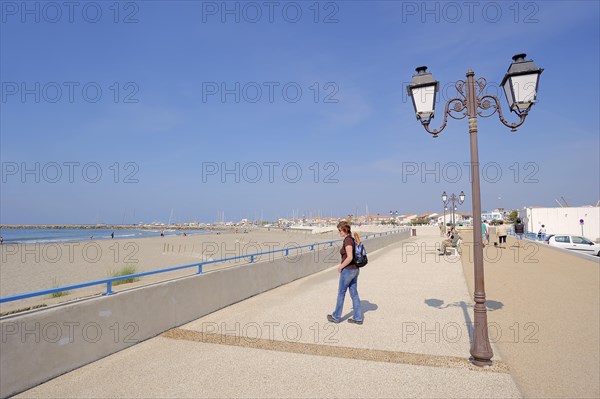 Woman on the beach promenade, Les Saintes-Maries-de-la-Mer, Camargue, Bouches-du-Rhone, Provence-Alpes-Cote d'Azur, South of France, France, Europe