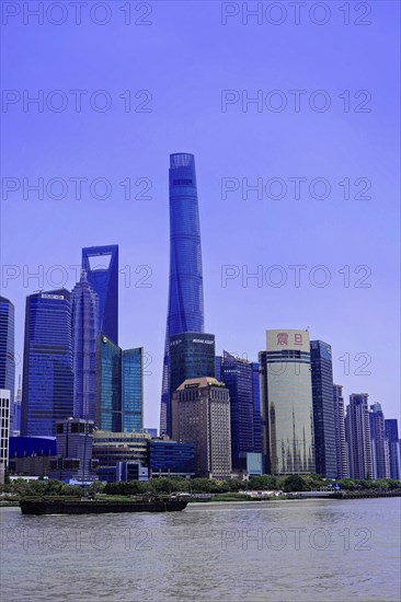 View from the Bund to the skyline at the Huangpu River with Oriental Pearl Tower, World Financial Centre, Shanghai Tower, Jin Mao-Building in Pudong district, Shanghai, China, Asia, Modern skyline of Shanghai with clear blue sky and water in the foreground, Asia