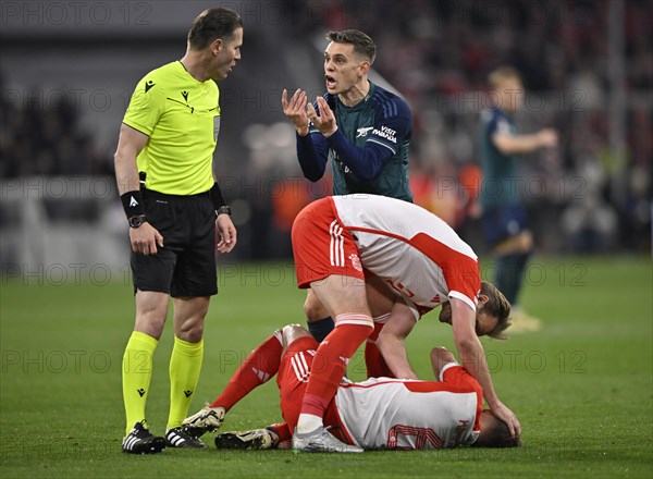 Referee Danny Makkelie (NED) in conversation, discussion with Leandro Trossard FC Arsenal (19), gesture gesture gesture, Joshua Kimmich FC Bayern Munich FCB (06) injured on the ground, Harry Kane FC Bayern Munich FCB (09) cares, Allianz Arena, Munich, Bavaria, Germany, Europe