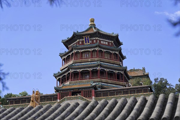 New Summer Palace, Beijing, China, Asia, A tall traditional Chinese tower rises above the trees against the blue sky, Beijing, Asia