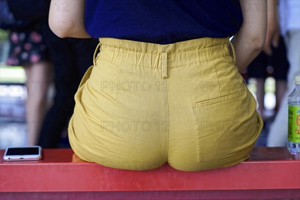 New Summer Palace, Beijing, China, Asia, A person sits on a red stripe, dressed in yellow trousers, background is blurred, Beijing, Asia