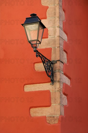 Kaysersberg, Alsace Wine Route, Alsace, Departement Haut-Rhin, France, Europe, An old lantern on a red wall casts a striking shadow, Europe