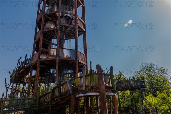 Wooden observation tower with winding staircase on top of mountain on sunny day with blue sky in South Korea