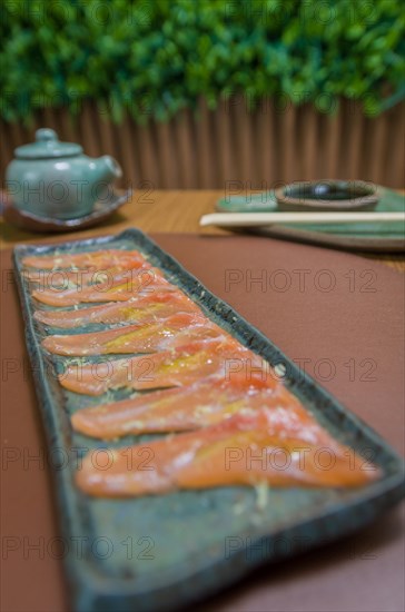 Delicious premium salmon sashimi arranged on an elegant handmade platter