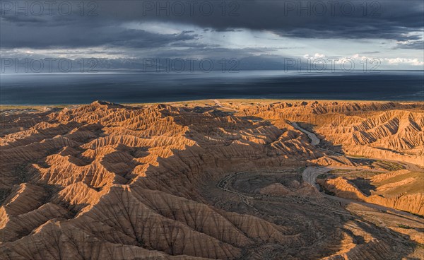 Evening mood, Canyon runs through landscape, Issyk Kul Lake, Dramatic barren landscape of eroded hills, Badlands, Canyon of the Forgotten Rivers, Issyk Kul, Kyrgyzstan, Asia