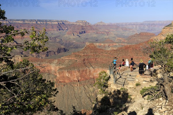 Visitors marvelling at the view of the Grand Canyon under a clear blue sky, Grand Canyon National Park, South Rim, North America, USA, South-West, Arizona, North America