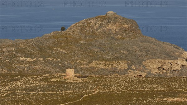 Ruins of a windmill, Hilly landscape with historical ruins and a path through the grass, Lindos, Rhodes, Dodecanese, Greek Islands, Greece, Europe