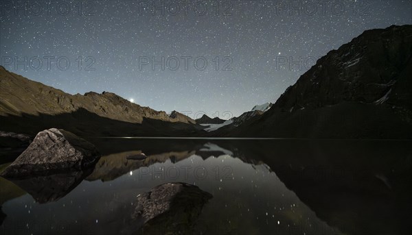 Starry sky reflected in the mountain lake Ala Kul Lake, mountain landscape by the lake at night, Ala Kul Lake, Tien Shan Mountains, Kyrgyzstan, Asia