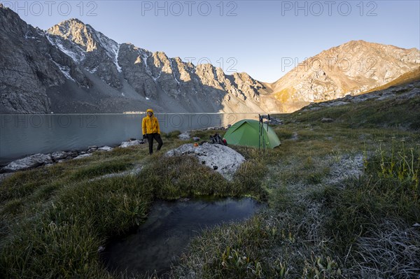 Hiker, camping in the wilderness, mountain lake in the Tien Shan, Lake Ala-Kul, Kyrgyzstan, Asia