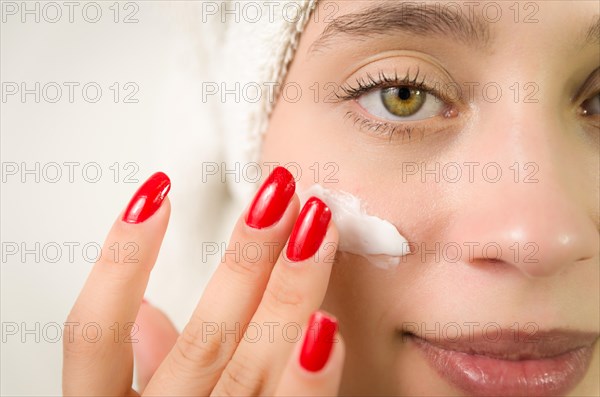 Hydration. Cream smear. Beuaty close up portrait of young woman with a healthy glowing skin is applying a skincare product