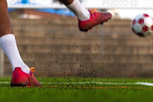 Player feet with the ball scoring a goal. Football player on the field running with the ball. Football player feet running with the ball in front of the goal field