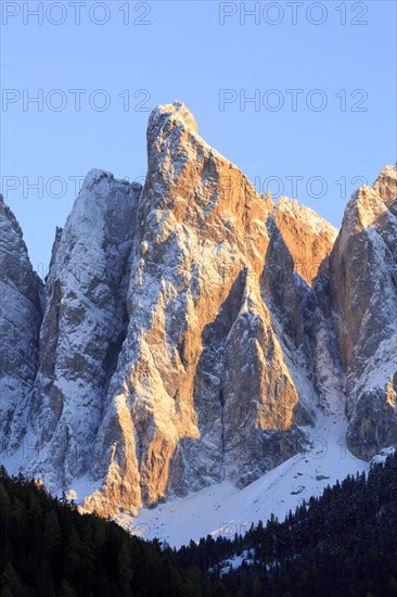 Dramatic view of a snow-covered mountain face during a sunrise, Italy, Trentino-Alto Adige, Alto Adige, Bolzano province, Dolomites, Santa Magdalena, St. Maddalena, Funes Valley, Odle, Puez-Geisler Nature Park in autumn, Europe