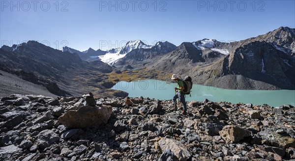 Mountaineers on the way to the Ala Kul Pass, view of mountains and glaciers and turquoise Ala Kul mountain lake, Tien Shan Mountains, Kyrgyzstan, Asia