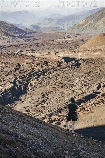 Young woman looking at lava fields, Crater Navidad, Lonquimay volcano, Malalcahuello National Reserve, Curacautin, Araucania, Chile, South America