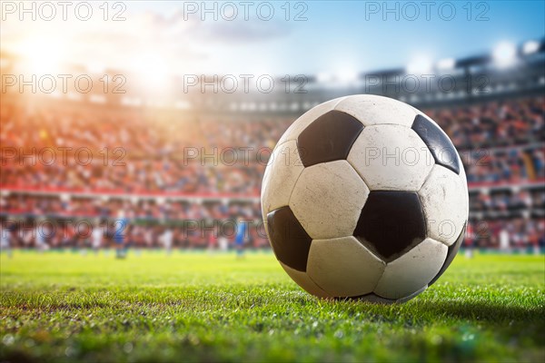A soccer ball on a green field in soccer football stadium in evening on sunset with floodlights lights during game, AI generated