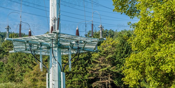 Large electrical tower with a steel wire platform located in a densely wooded area in South Korea