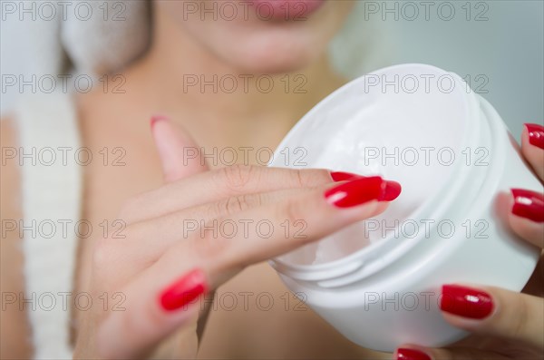 Hydration. Cream smear. Beuaty close up portrait of young woman with a healthy glowing skin is applying a skincare product