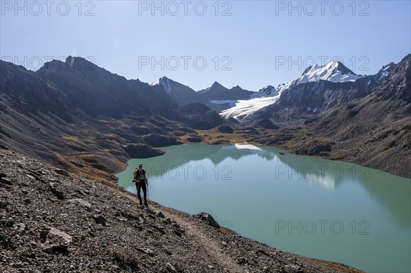 Trekking, hiker in the Tien Shan high mountains, mountain lake Ala-Kul Lake, 4000 metre peak with glacier, Ak-Su, Kyrgyzstan, Asia