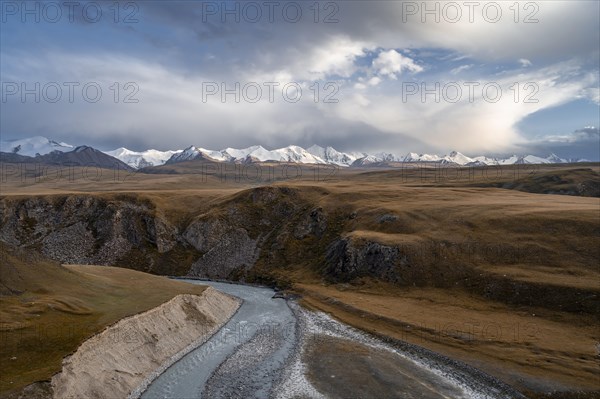 Mountain valley with Sary Jaz river, high glaciated mountain peaks of the Tien Shan in the background, autumn mountains with yellow grass, Tien Shan, Kyrgyzstan, Asia