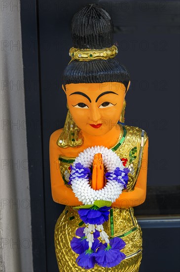 Figure with wreath of flowers at the entrance to the Thai massage parlour, Kaufbeuern, Allgaeu, Swabia, Bavaria, Germany, Europe