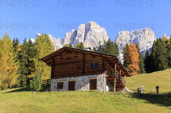Rustic alpine hut against a backdrop of rugged mountains in autumn, Italy, Alto Adige, Bolzano province, Dolomites, rose garden, Europe