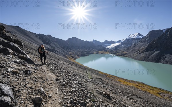 Trekking, hiker in the Tien Shan high mountains, mountain lake Ala-Kul Lake, 4000 metre peak with glacier, Ak-Su, Kyrgyzstan, Asia