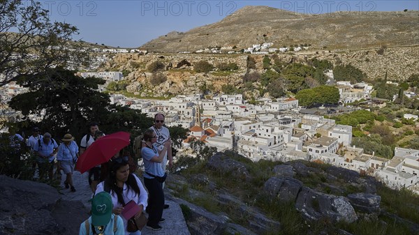 Way to the Acropolis, tourists walking on a path near a traditional mountain village, Lindos, Rhodes, Dodecanese, Greek Islands, Greece, Europe
