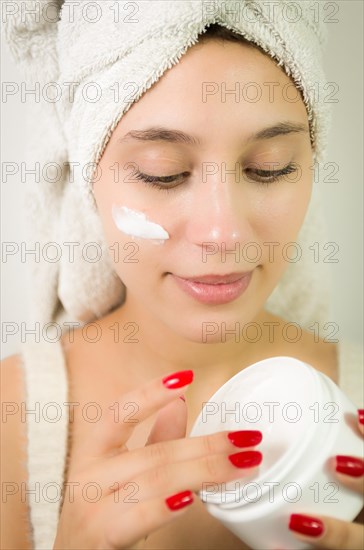 Hydration. Cream smear. Beuaty close up portrait of young woman with a healthy glowing skin is applying a skincare product