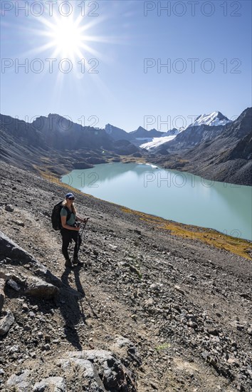 Trekking, hiker in the Tien Shan high mountains, mountain lake Ala-Kul Lake, 4000 metre peak with glacier, Ak-Su, Kyrgyzstan, Asia