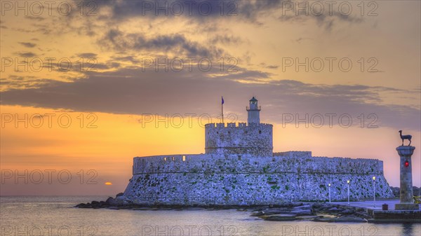 The fortress near the coast under a sky with sunset colours, sunrise, dawn, lighthouse, European roe deer statue, Fort of Saint Nikolaos, harbour promenade, Rhodes, Dodecanese, Greek Islands, Greece, Europe