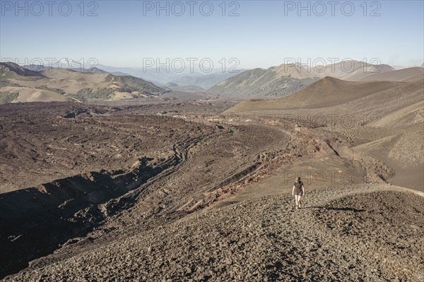 Young woman walking through lava fields, Crater Navidad, Lonquimay volcano, Malalcahuello National Reserve, Curacautin, Araucania, Chile, South America